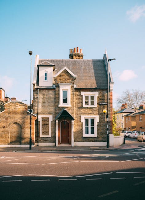 A row of Victorian-style terraced houses constructed with red brick and white decorative architectural features, including ornate window surrounds and cornices. Each property has a small front garden 